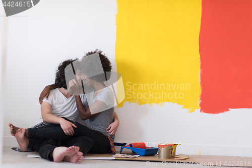 Image of young multiethnic couple relaxing after painting