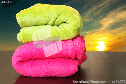 Image of colorful towels prepared for sunset bath in the sea