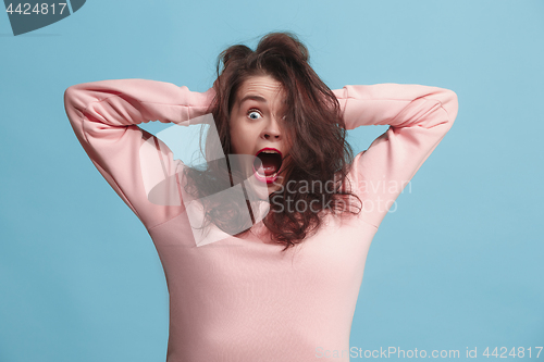 Image of The squint eyed woman with weird expression isolated on blue