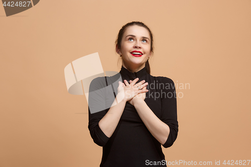 Image of The happy business woman standing and smiling against pastel background.