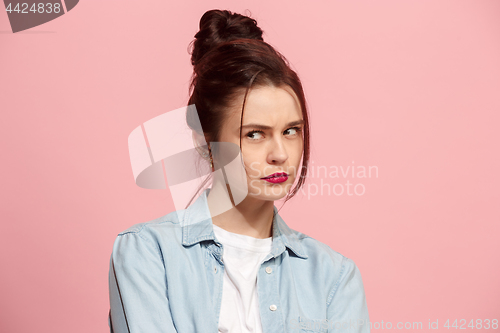 Image of Suspiciont. Doubtful pensive woman with thoughtful expression making choice against pink background