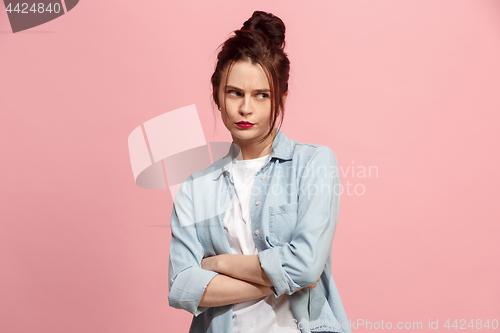 Image of Suspiciont. Doubtful pensive woman with thoughtful expression making choice against pink background