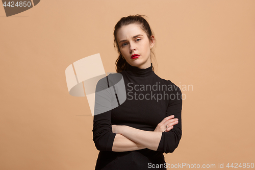 Image of The serious business woman standing and looking at camera against pastel background.