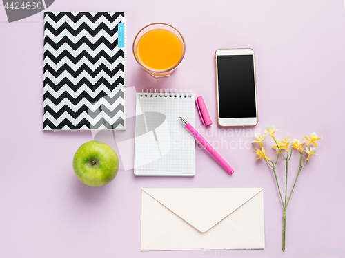 Image of The top view on female desk. The phone and french macarons on trendy pink desk.