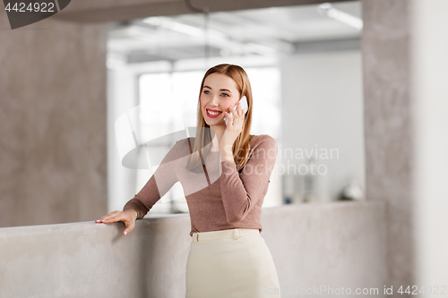 Image of businesswoman calling on smartphone at office