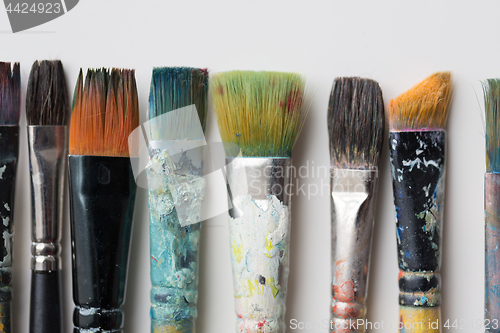 Image of close up of dirty paintbrushes from top