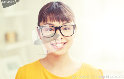 Image of happy asian young woman in glasses at home