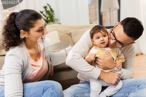 Image of happy family with baby daughter at home