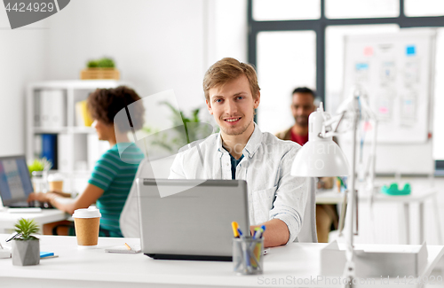 Image of creative male office worker with laptop