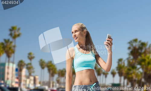 Image of woman with smartphone doing sports in los angeles