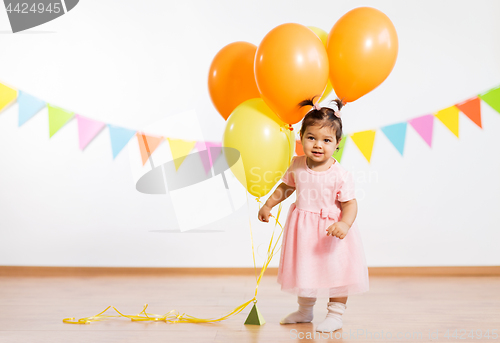 Image of happy baby girl with balloons on birthday party