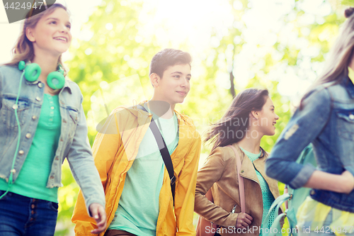 Image of group of happy teenage students walking outdoors