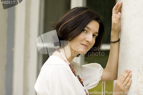 Image of woman standing near white column