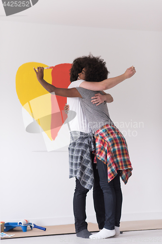 Image of couple with painted heart on wall