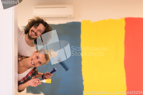 Image of portrait of a couple painting interior wall
