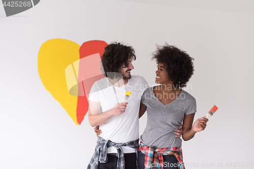 Image of couple with painted heart on wall