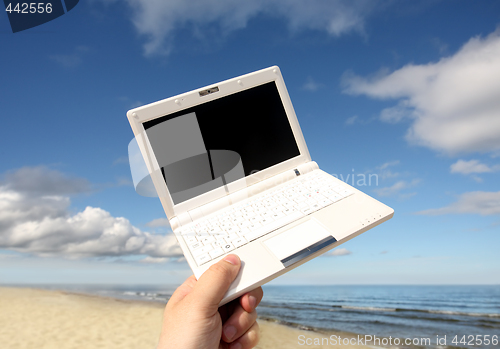 Image of White small  Laptop on the beach