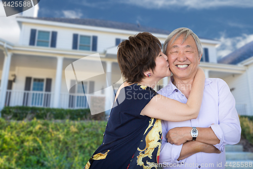 Image of Happy Chinese Senior Adult Couple Kissing In Front Of Custom Hou