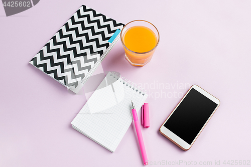 Image of The top view on female desk. The phone and french macarons on trendy pink desk.