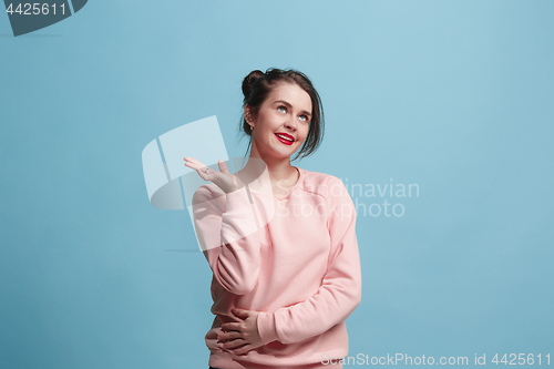 Image of The happy business woman standing and smiling against blue background.