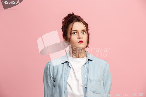 Image of Portrait of an angry woman looking at camera isolated on a pink background