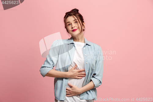 Image of The happy business woman standing and smiling against pink background.