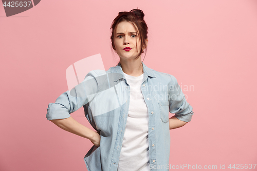 Image of Portrait of an angry woman looking at camera isolated on a pink background