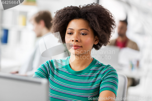 Image of african woman with laptop computer at office