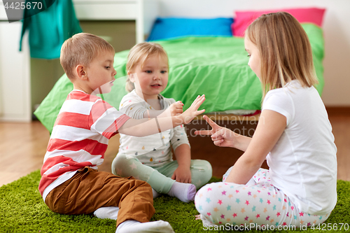 Image of kids playing rock-paper-scissors game at home