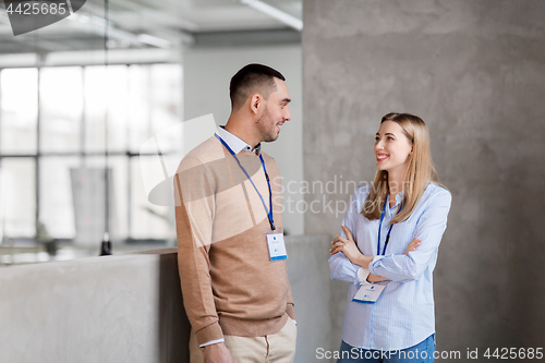 Image of man and woman with conference badges at office