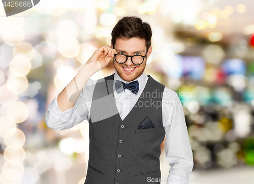 Image of happy man in suit and eyeglasses over lights