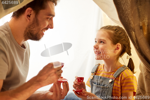 Image of family playing tea party in kids tent at home