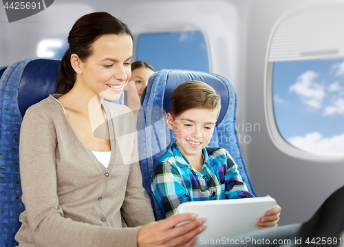 Image of happy family with tablet pc sitting in plane