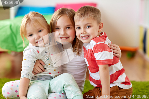 Image of happy little kids hugging at home