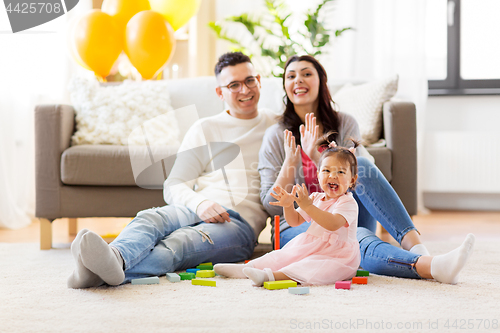 Image of baby girl with parents clapping hands at home