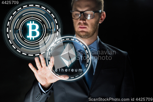 Image of businessman with ethereum and bitcoin holograms