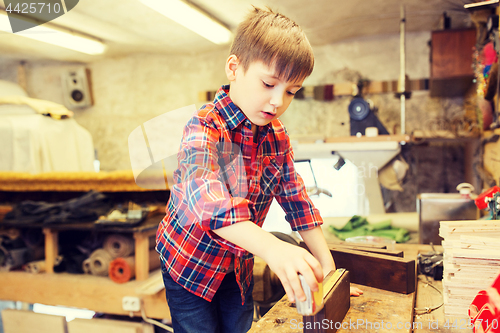 Image of happy little boy with plank and ruler at workshop