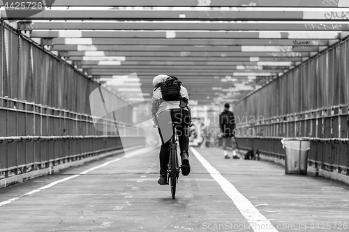 Image of Man riding his bike in the cycling lane on Williamsburg Bridge, Brooklyn, New York City.