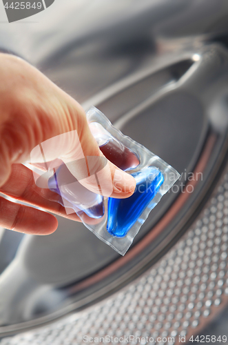 Image of gel cap in hand for washing mashine 