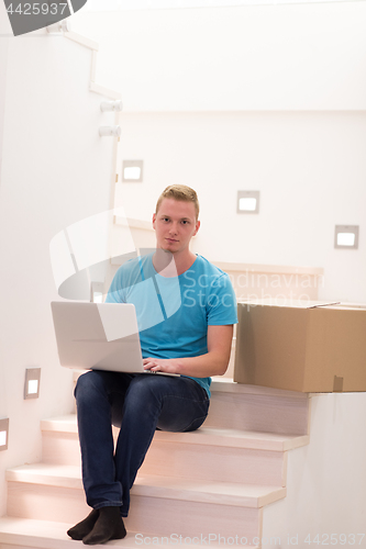 Image of young man sitting in stairway at home