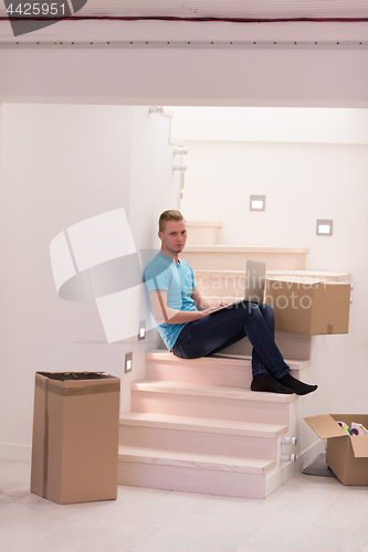 Image of young man sitting in stairway at home