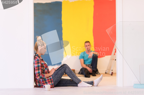 Image of Happy young couple relaxing after painting