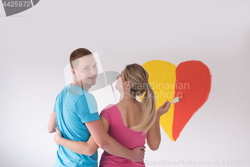 Image of couple are painting a heart on the wall