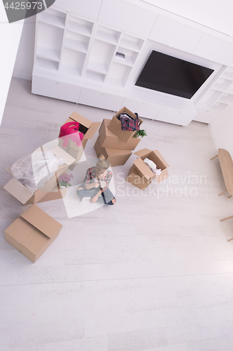 Image of woman with many cardboard boxes sitting on floor