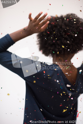 Image of African American woman blowing confetti in the air