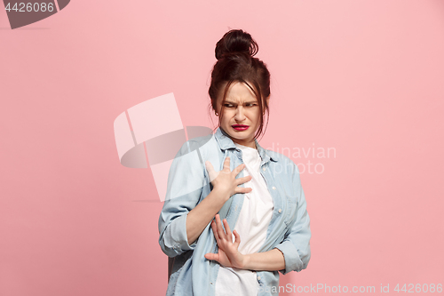 Image of Young woman with disgusted expression repulsing something, isolated on the pink