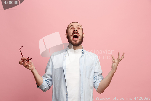 Image of The young emotional angry man screaming on pink studio background