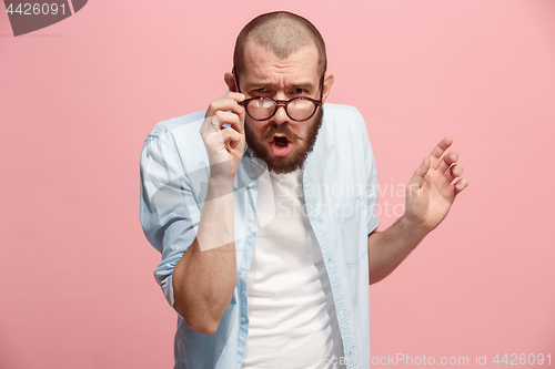 Image of Suspiciont. Doubtful pensive man with thoughtful expression making choice against pink background