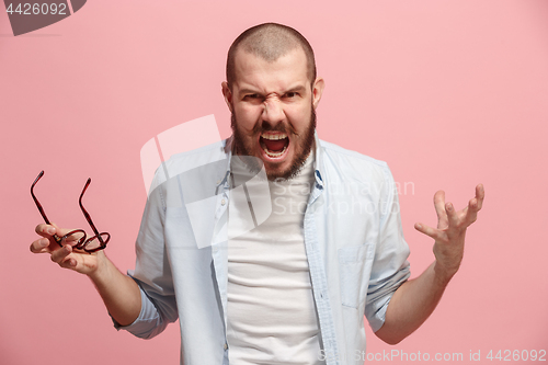 Image of The young emotional angry man screaming on pink studio background