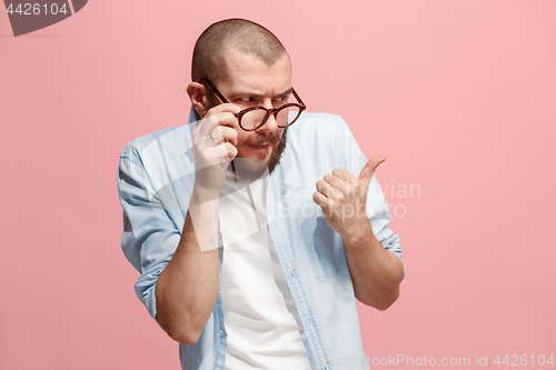 Image of Suspiciont. Doubtful pensive man with thoughtful expression making choice against pink background